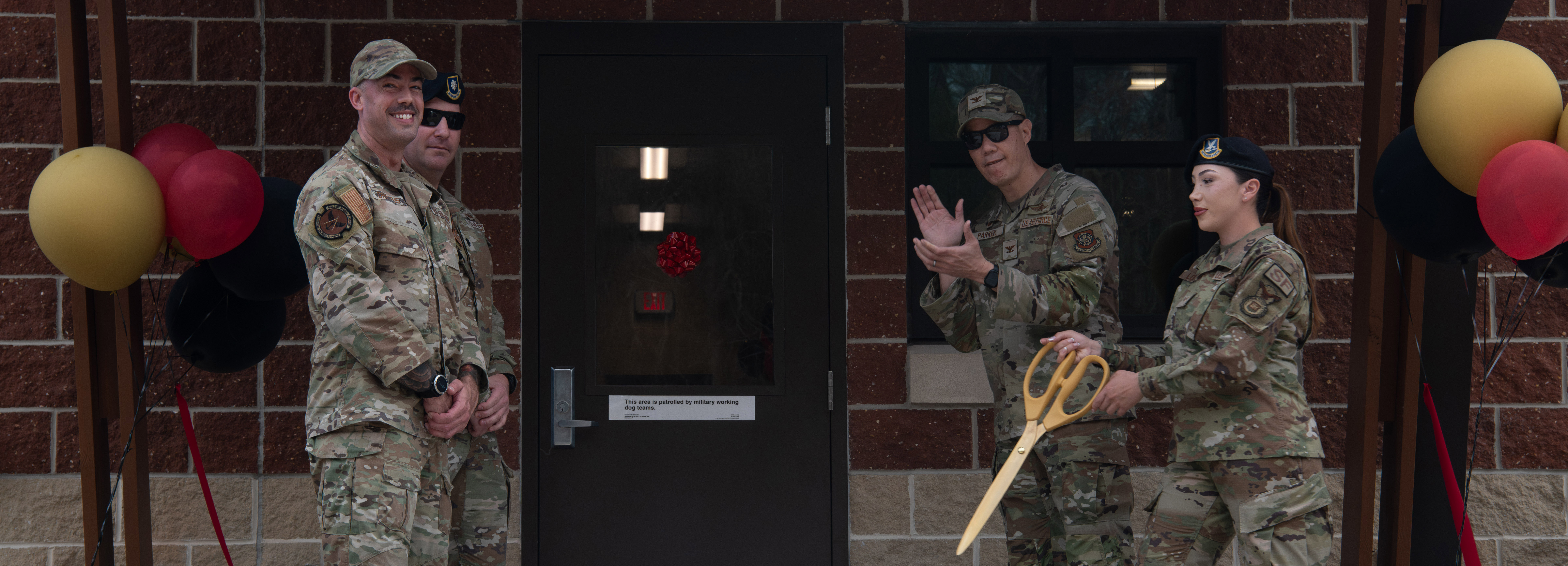 Base leadership and Security Forces Squadron cuts ribbon at new kennel facility.